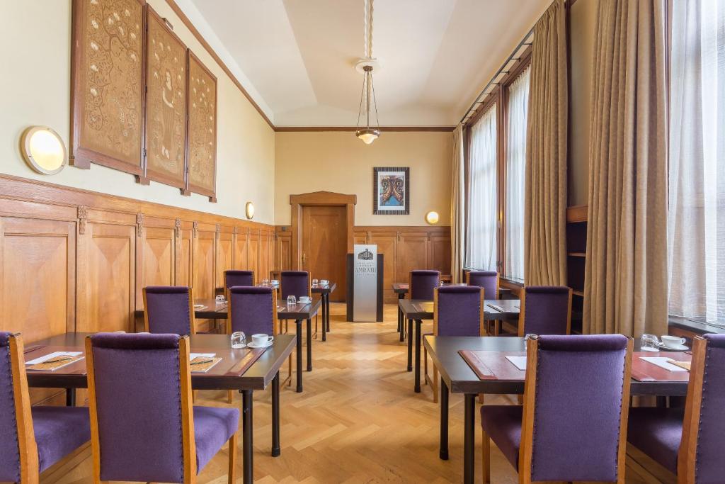 a restaurant with tables and chairs in a room at Grand Hotel Amrâth Amsterdam in Amsterdam