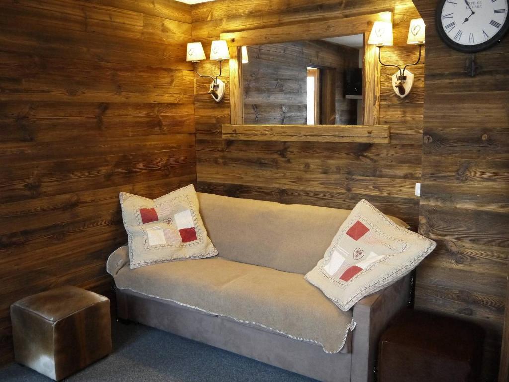 une chambre avec un canapé, un miroir et une horloge dans l'établissement Appartement 2 chambres avec mezzanine, piste skis aux pieds - FR-1-355-77, à Méribel