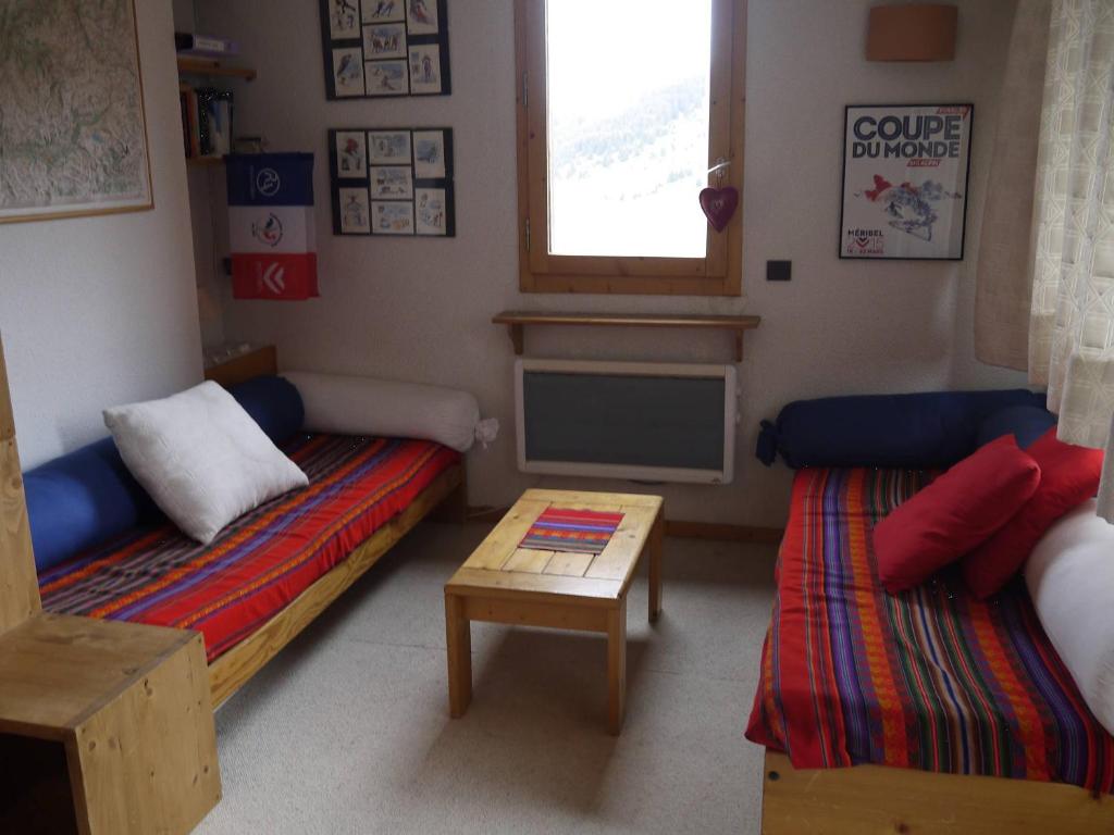 une petite chambre avec deux lits et une table dans l'établissement Dupleix 2 chambres, balcon, proche pistes et commerces - FR-1-355-39, à Les Allues