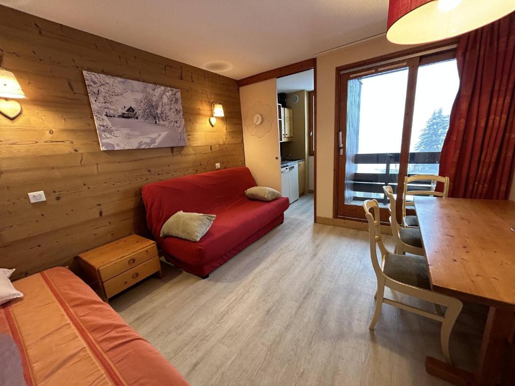 un salon avec un canapé rouge et une table dans l'établissement Appartement rénové à Méribel, 1 chambre, 3 couchages, balcon, accès pistes, casier à skis, WIFI - FR-1-355-175, à Les Allues