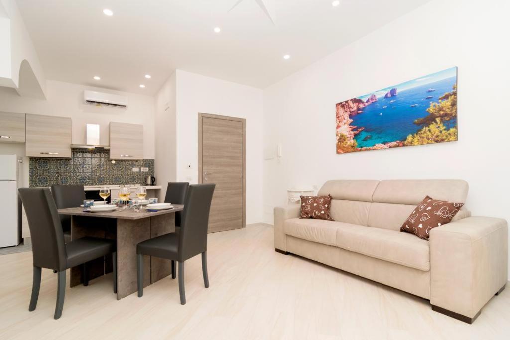 a living room with a couch and a table with chairs at Carpe Diem Holiday House in Massa Lubrense