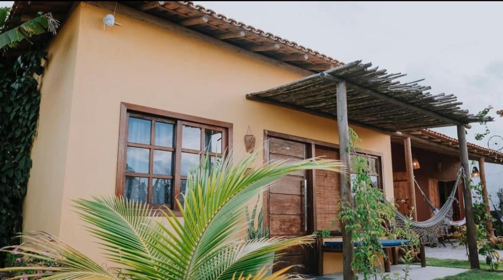 una casa con una palma di fronte di Vila Corumbau Cacau a Corumbau