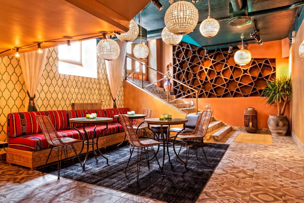 ストックホルムにあるソフォ ホテルの赤いソファ、テーブル、椅子が備わるレストラン