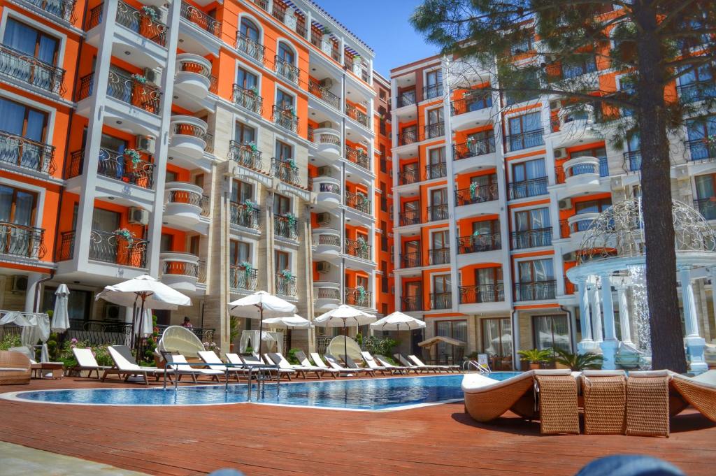 a hotel with a swimming pool and chairs and umbrellas at Harmony Palace in Sunny Beach