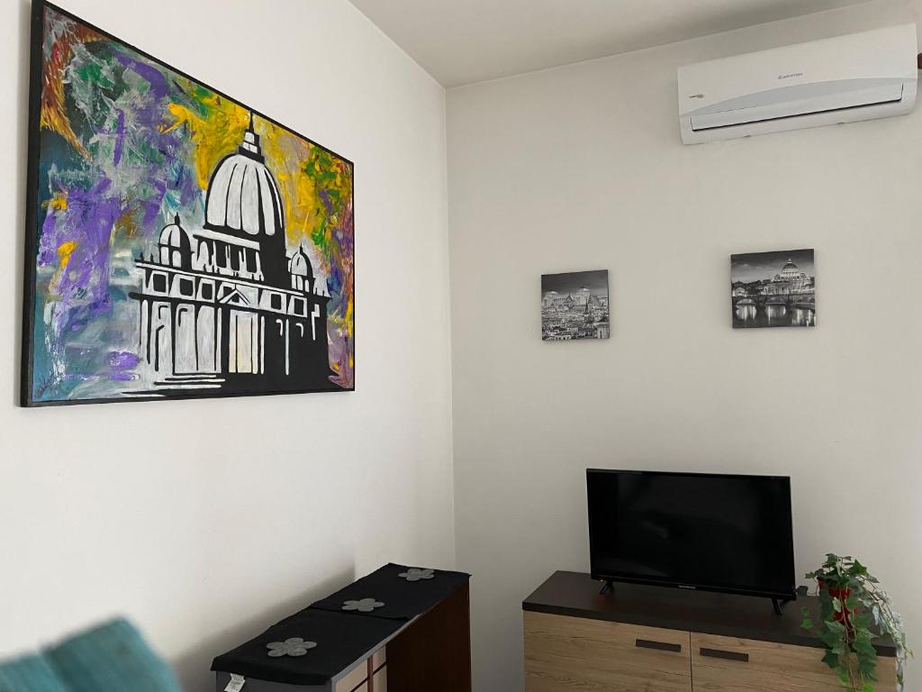 a living room with a tv and a painting on the wall at Pisana 247 St Peter in Rome