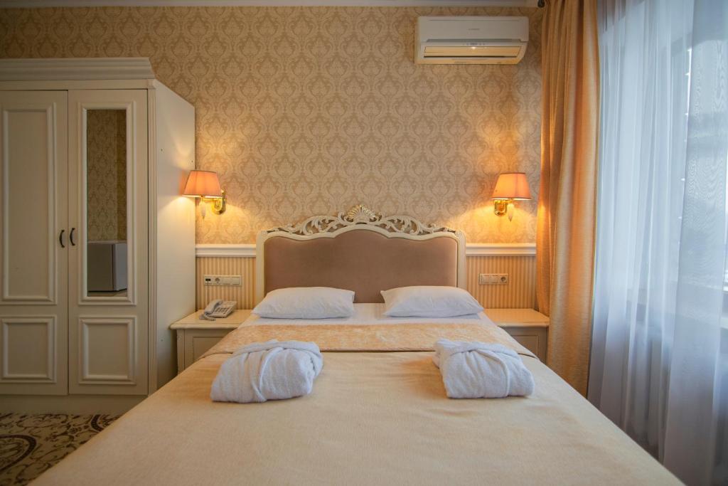 Postel nebo postele na pokoji v ubytování Royal Olympic Hotel
