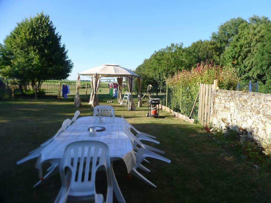 a white table and chairs in a yard with a tent at location thezacaise in Thézac