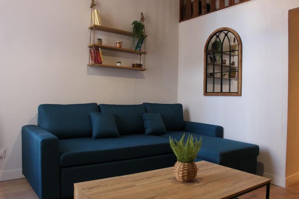 un canapé bleu dans un salon avec une table dans l'établissement Joli Duplex avec Terrasse, à Montpellier