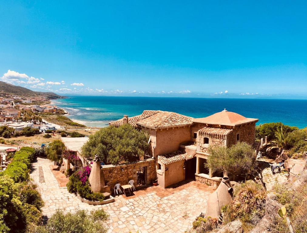 an old house on a hill next to the ocean at Villa TirNaNog in Castelsardo