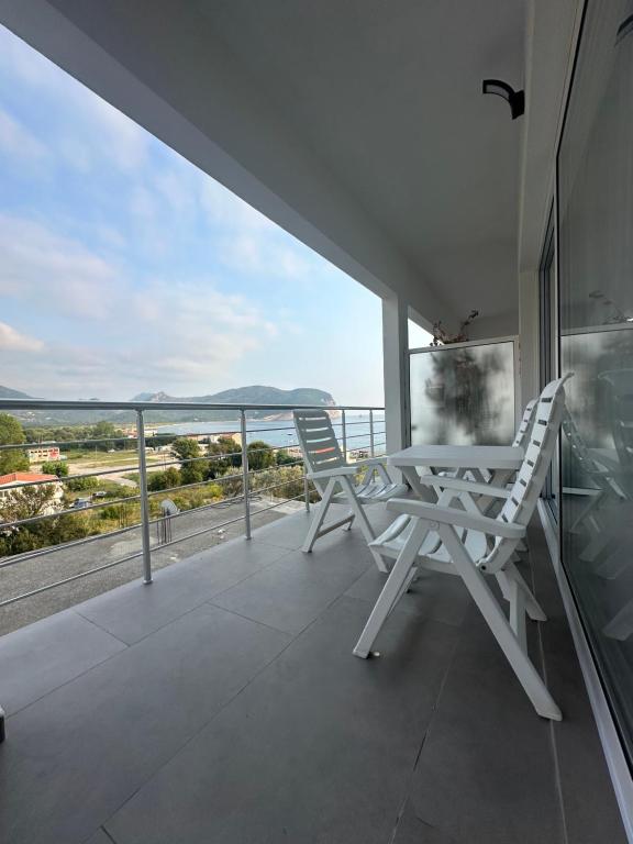 a white table and chairs on a balcony with a view at Apartments Sea Side in Petrovac na Moru