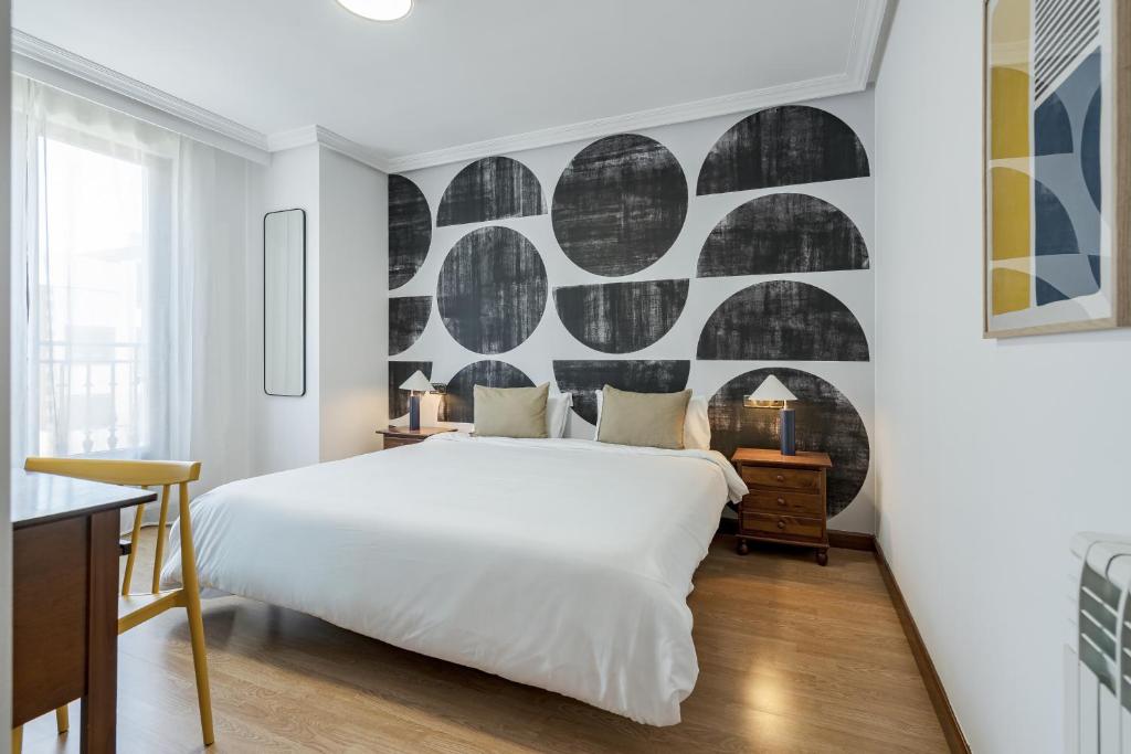 a bedroom with a white bed and a wall with circles at Rio Apartments by Olala Homes in Salamanca