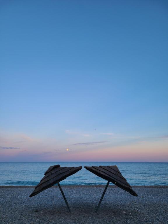- deux parasols assis sur la plage au coucher du soleil dans l'établissement Villa Ange Azur, à Villeneuve-Loubet