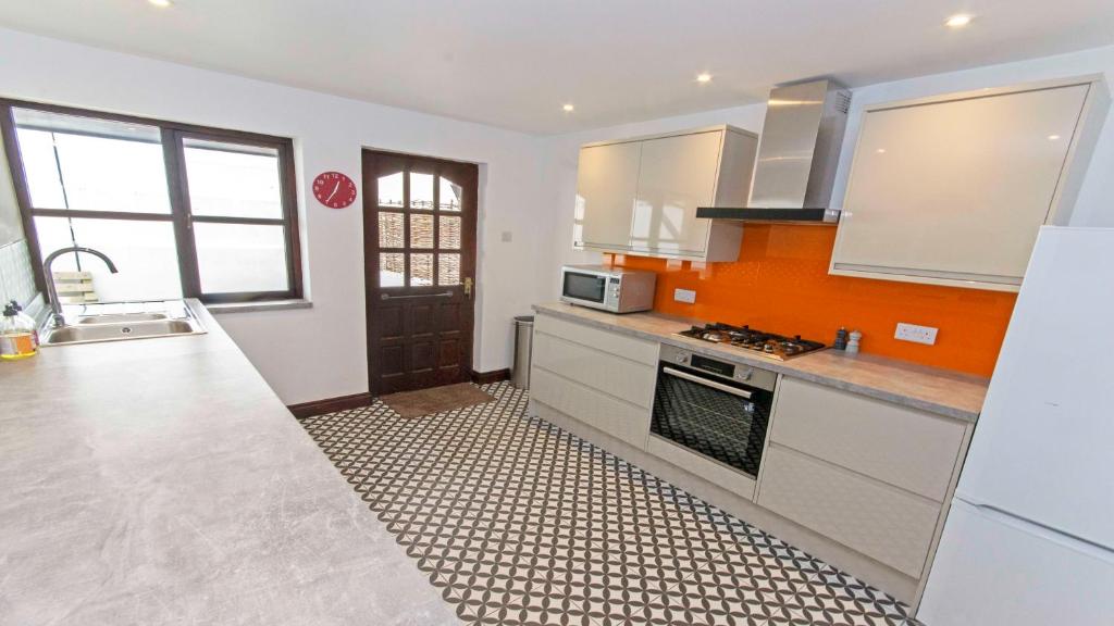 a kitchen with an orange and white tile floor at Rockham Bay View - Sleeps 6 Mortehoe in Mortehoe