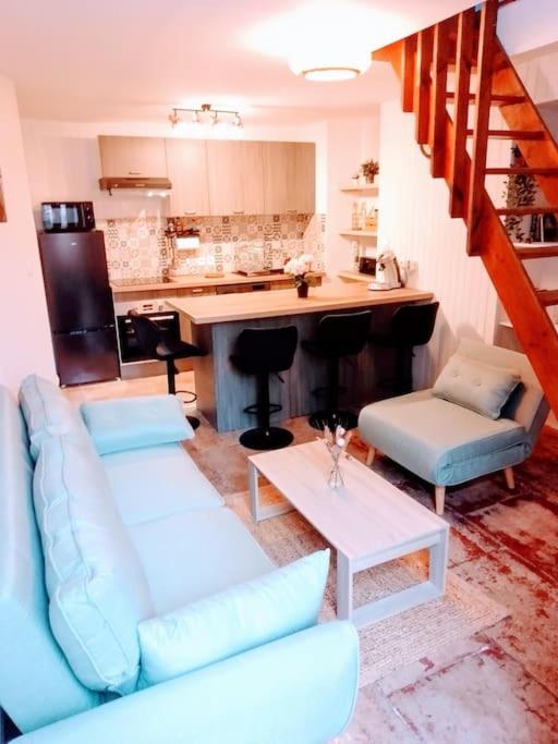 un salon avec un canapé bleu et une cuisine dans l'établissement Superbe T2 avec Terrasse, à Montpellier