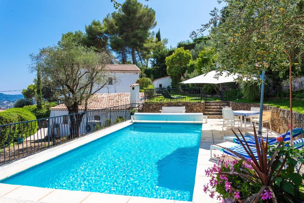 - une piscine dans une cour avec des chaises et un parasol dans l'établissement VILLA LA ROSERAIE VI4425 By Riviera Holiday Homes, à Mougins