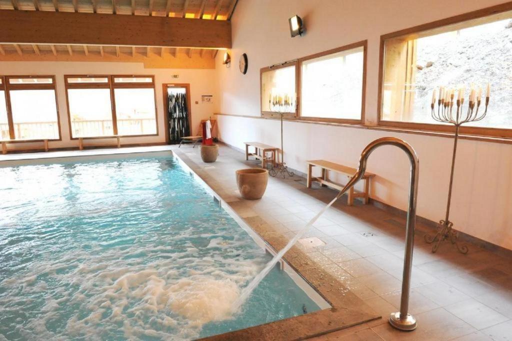 - une grande piscine dans une pièce dotée de fenêtres dans l'établissement Hameau des Eaux d'Orelle 3 Vallées - 2 Studios Communicants, à Orelle