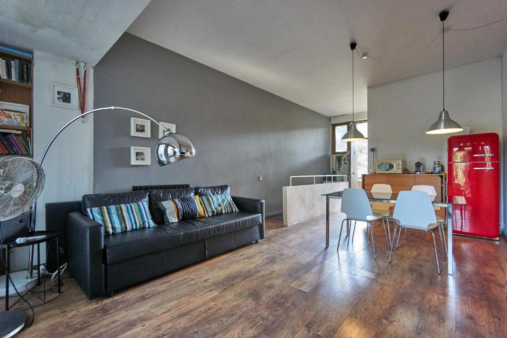 a living room with a black couch and a table at 300metri dal mare in contesto naturale in Torre del Lago Puccini