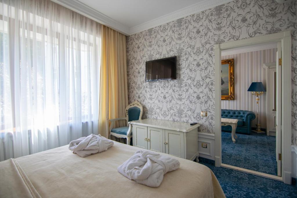 Postel nebo postele na pokoji v ubytování Royal Olympic Hotel