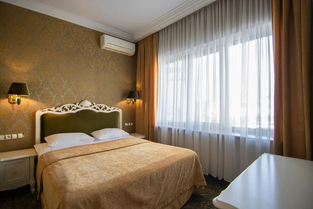 Postel nebo postele na pokoji v ubytování Royal Olympic Hotel