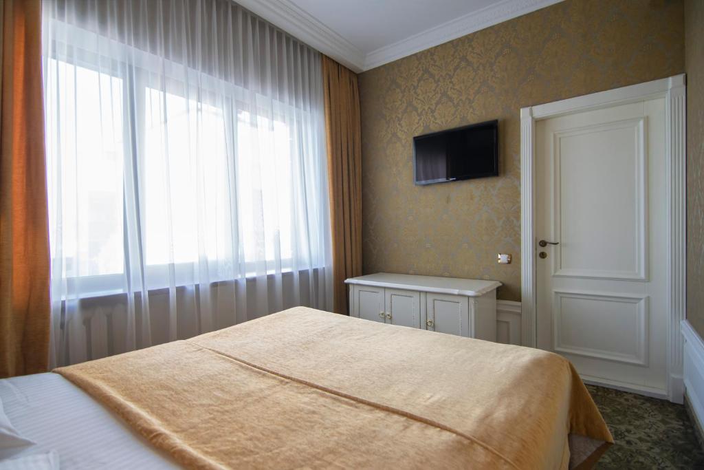 Postel nebo postele na pokoji v ubytování Royal Olympic Hotel