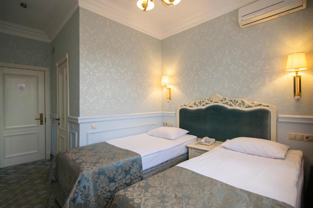 Postel nebo postele na pokoji v ubytování Royal Olympic Hotel