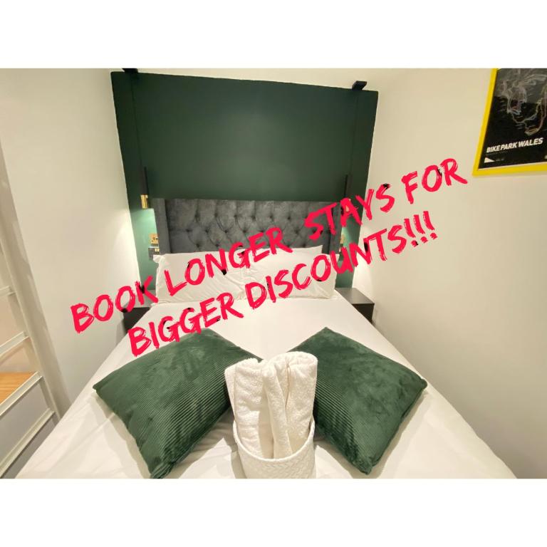 a sign is posted above a bed with green pillows at The Cwtch, Log Fire, Sleeps 6, Nr Zip World, Brecon and Bike Park Wales in Aberdare