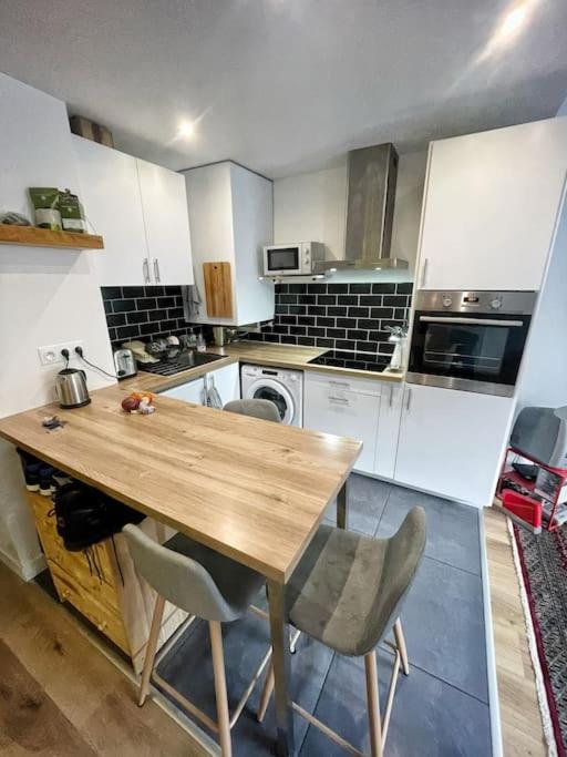 une cuisine avec une table et des chaises en bois dans l'établissement Le repère du voyageur, à Nantes