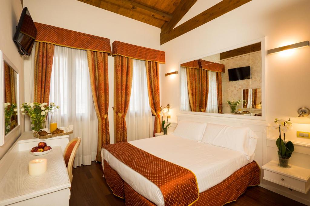 a hotel room with a bed and a table at Casanova Fourrooms in Venice