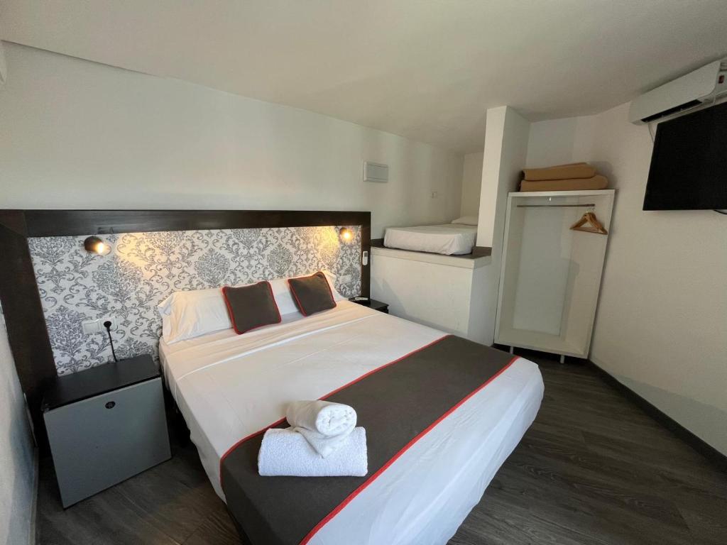 a bedroom with a large bed and two bunk beds at Hello Feria in Madrid