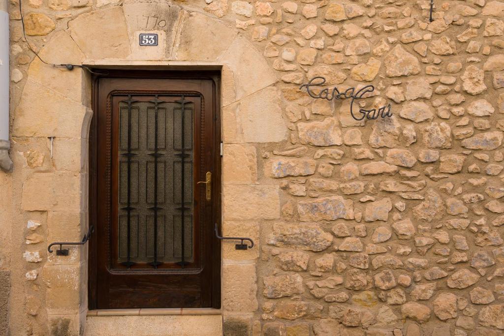 a stone building with a wooden door and a window at Casa Garí in Horta de San Joan