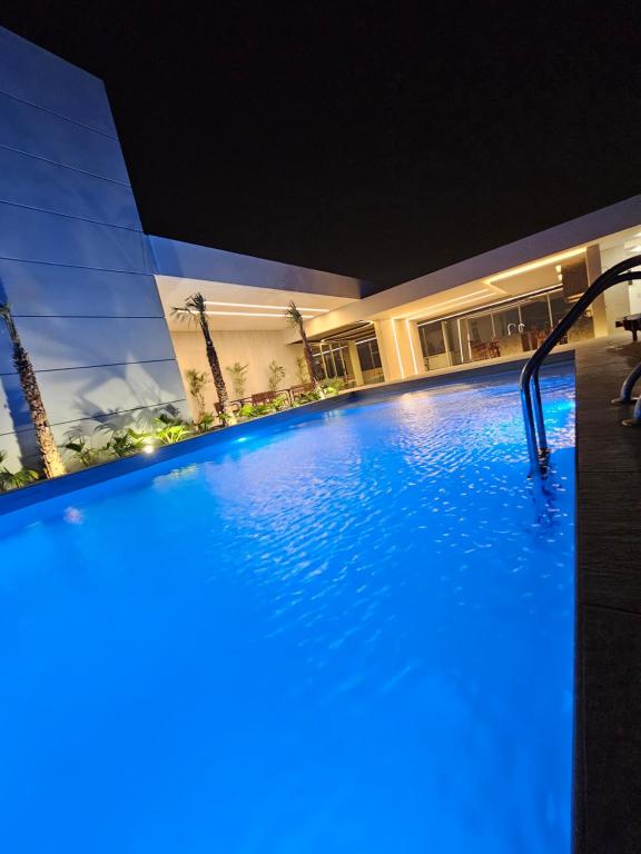 a large swimming pool at night with blue lighting at Departamento de lujo en EQUIPETROL in Santa Cruz de la Sierra