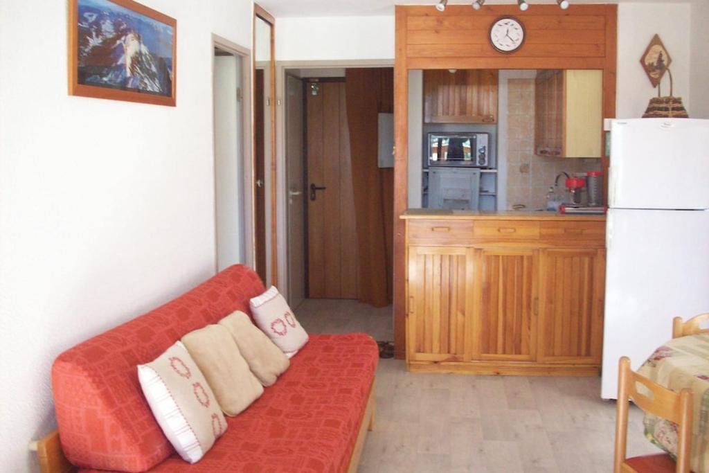 un salon avec un canapé rouge et une cuisine dans l'établissement #AH3 The Snow White, à Huez