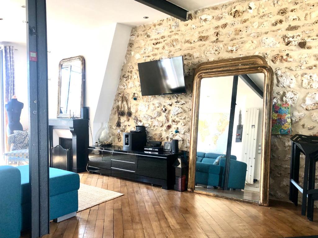 - un salon avec un miroir et un canapé bleu dans l'établissement Duplex atypique proche Montparnasse & parc expositions, à Paris