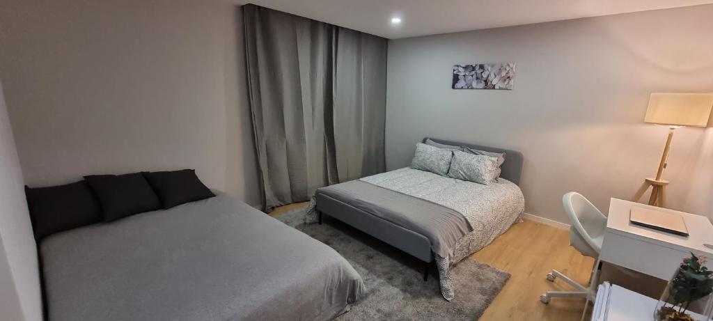 una piccola camera da letto con un letto e una sedia di Confortável ensuite 1 privado centro da cidade a Póvoa de Varzim