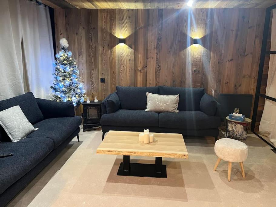 un salon avec un canapé bleu et un sapin de Noël dans l'établissement Appartement Chic et Cosy, à Aime La Plagne