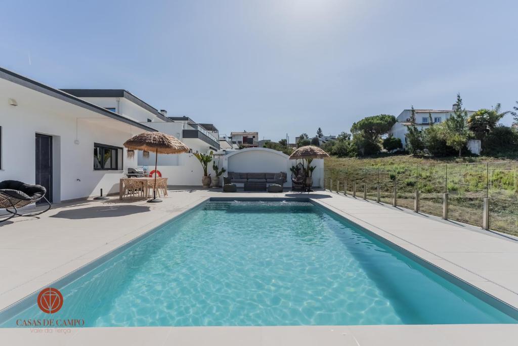 a villa with a swimming pool and a house at Casas de Campo - Vale da Terça in Vermelho