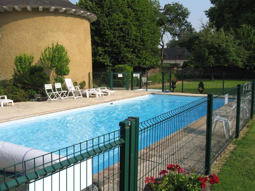 a fence around a swimming pool in a yard at Appartement Domaine de la Freslonnière in Le Rheu