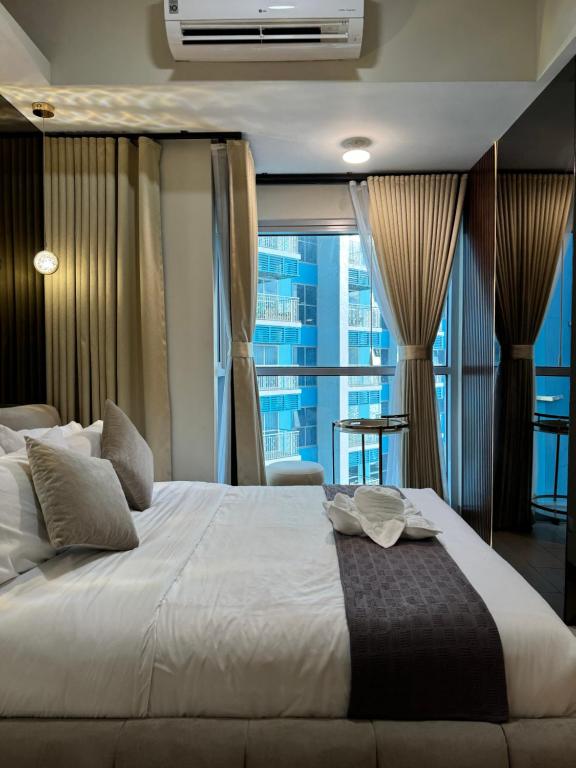 a bedroom with a large bed with a large window at Stylish 1BR Near Airport Facing the Bay - 9d in Manila
