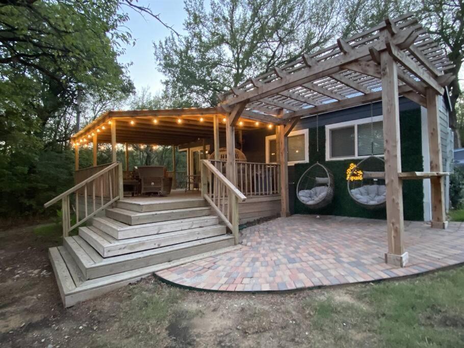 a house with a deck with a pergola at Stargazer Tiny Cottage in Shay