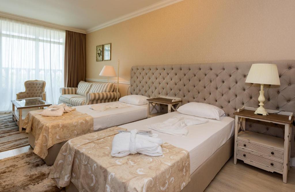A bed or beds in a room at Therma Palace - All inclusive & Private Beach & Free Parking