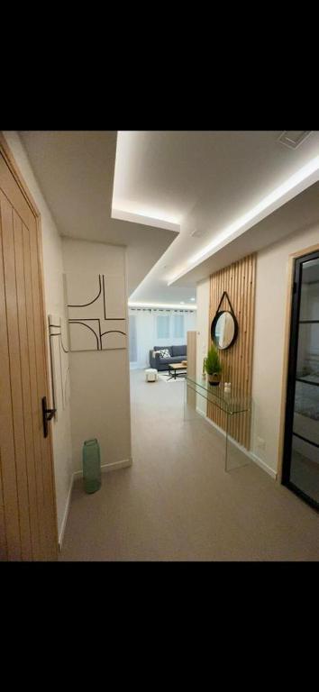 un couloir d'un salon avec une horloge sur le mur dans l'établissement APPARTEMENt COSY, à Nice