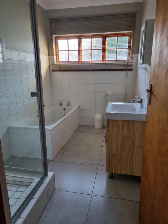 un bagno con vasca e lavandino di The Cottage a Cradock