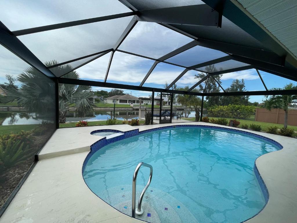 une grande piscine avec un toit en verre dans l'établissement The Cape Escape, à Cape Coral
