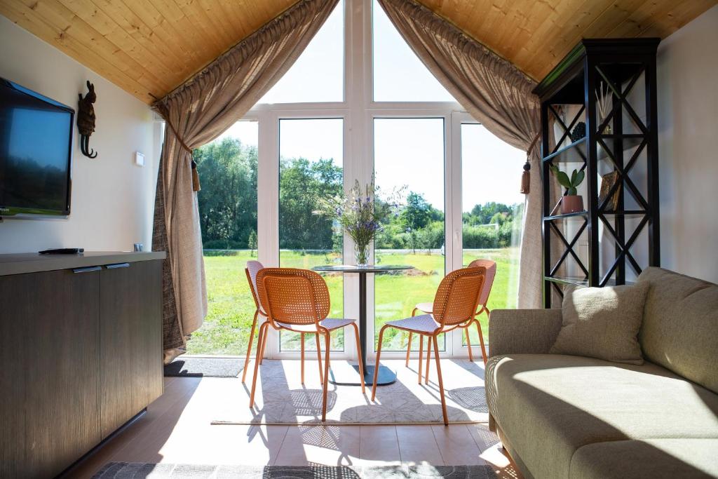 a living room with a table and chairs in front of a window at Seaside wellbeing in Dargužiai