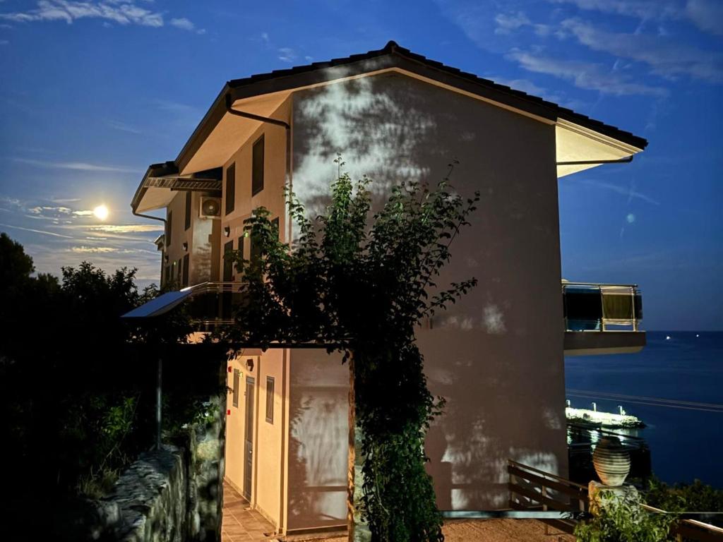 a house with a door in front of the ocean at Sarti Thea in Sarti