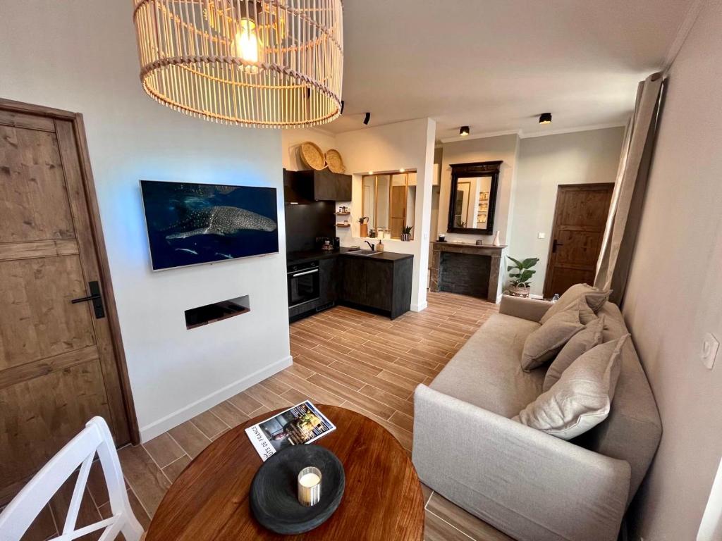 a living room with a couch and a table at Appartement de Charme - Le Large in La Tente-Verte