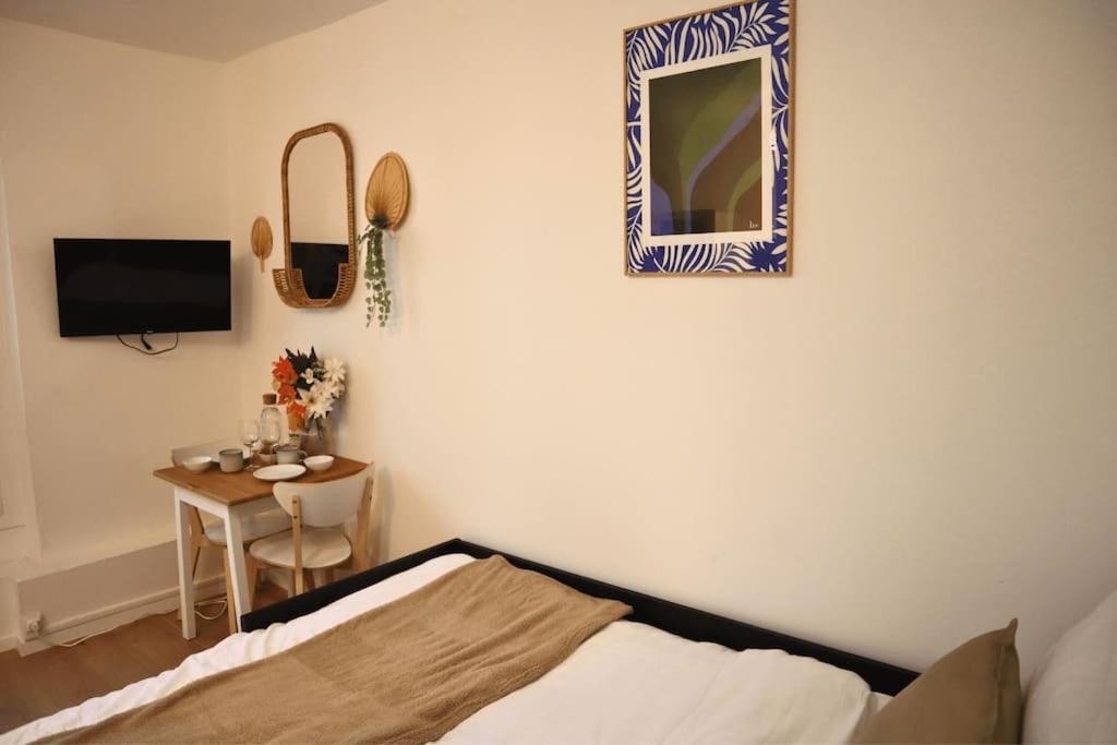 En eller flere senge i et værelse på Charmant Appartement à Paris 2P