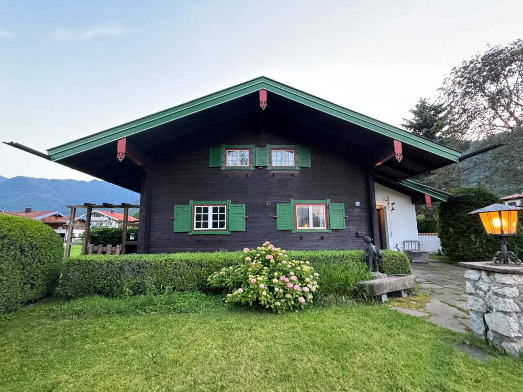 シュレヒングにあるHaus Bergsteigerglückの庭の緑の襖と花の黒い家