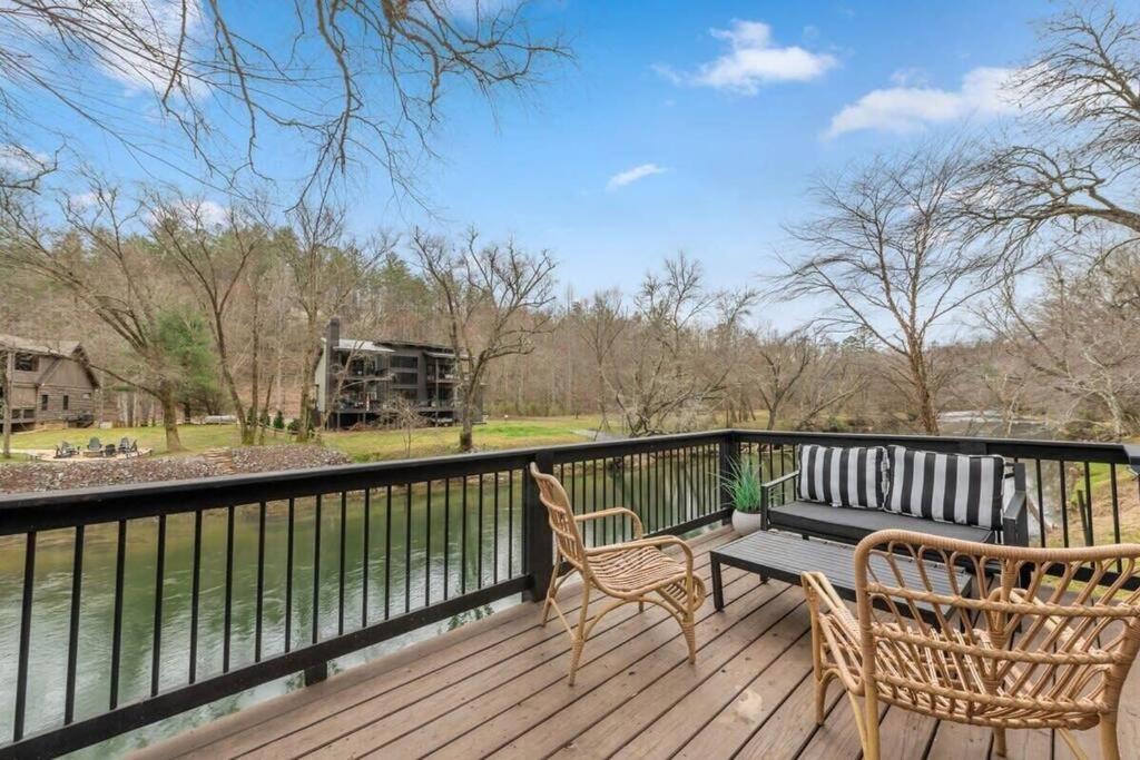 a wooden deck with two chairs and a bench on it at NEW Toccoa River Front - HotTub Fire pit Game Room in Mineral Bluff