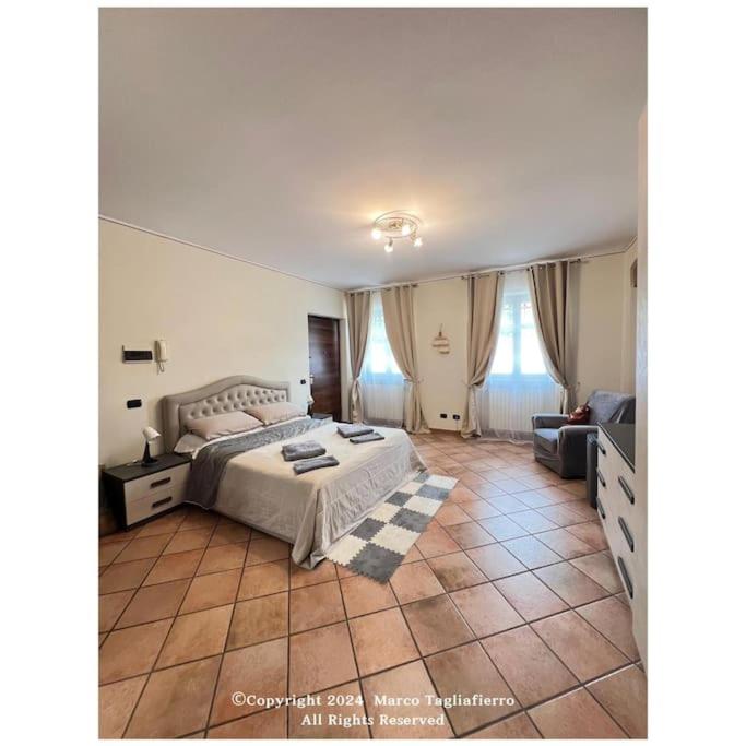 Un dormitorio grande con una cama y un sofá. en appartamento dolcevita, en Alba